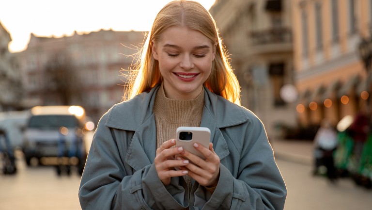 Young woman looking at her mobile smiling