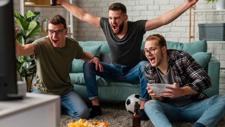 Three young guys watching football