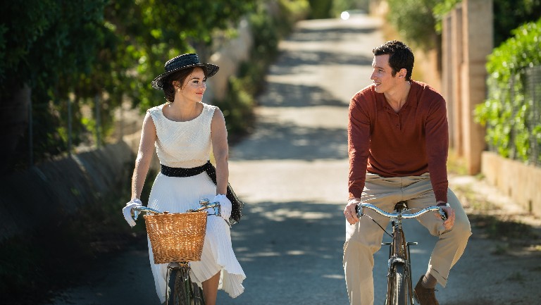 A young man and woman cycling next to each other