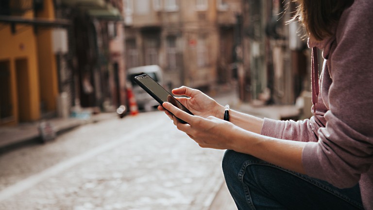 Person sitting down holding a mobile device