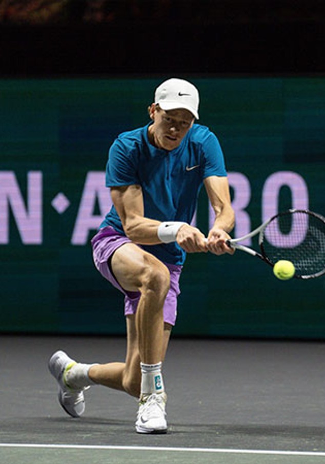 Tennis player with his racket trying to catch the ball