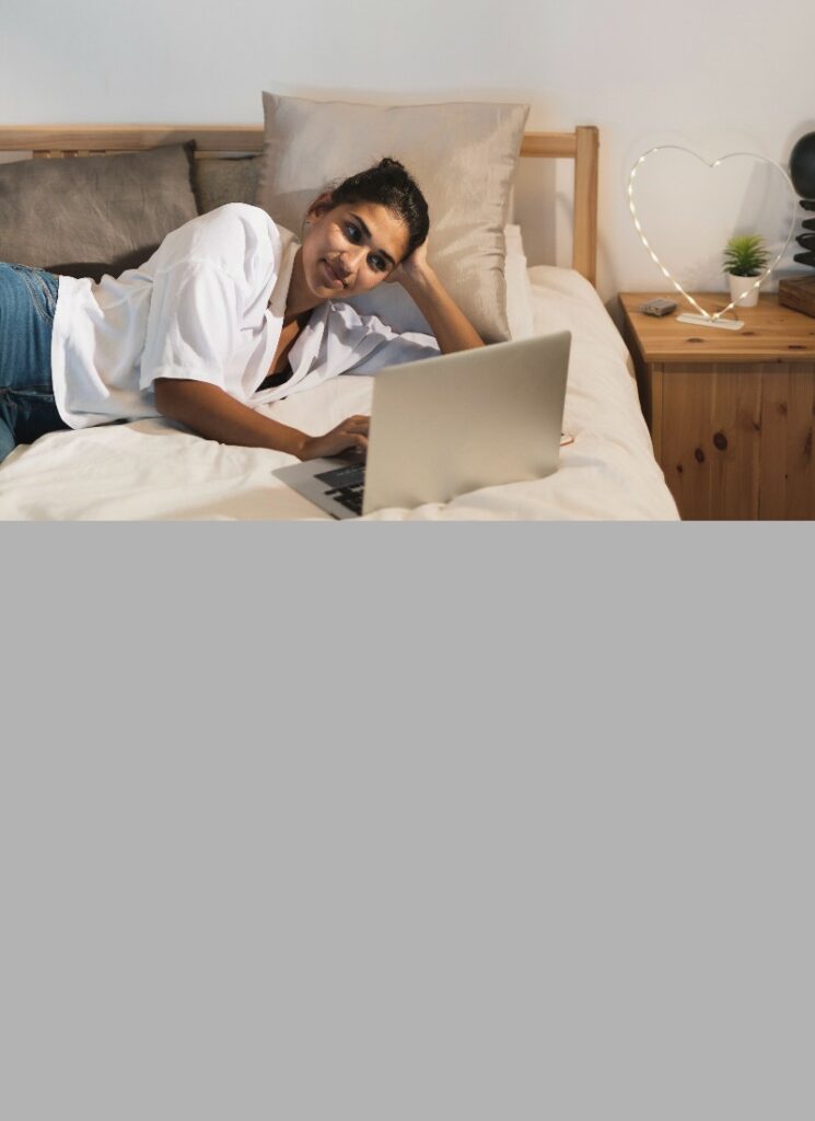 Woman laying on the bed with a laptop