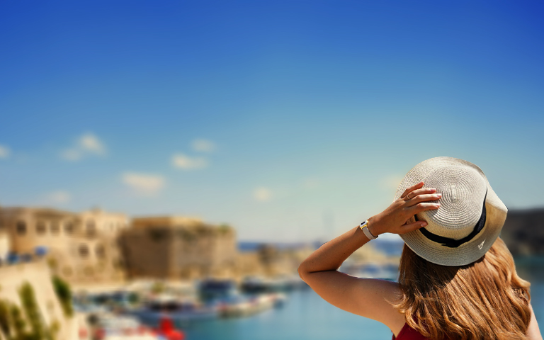 Woman looking at scenery holding her hat